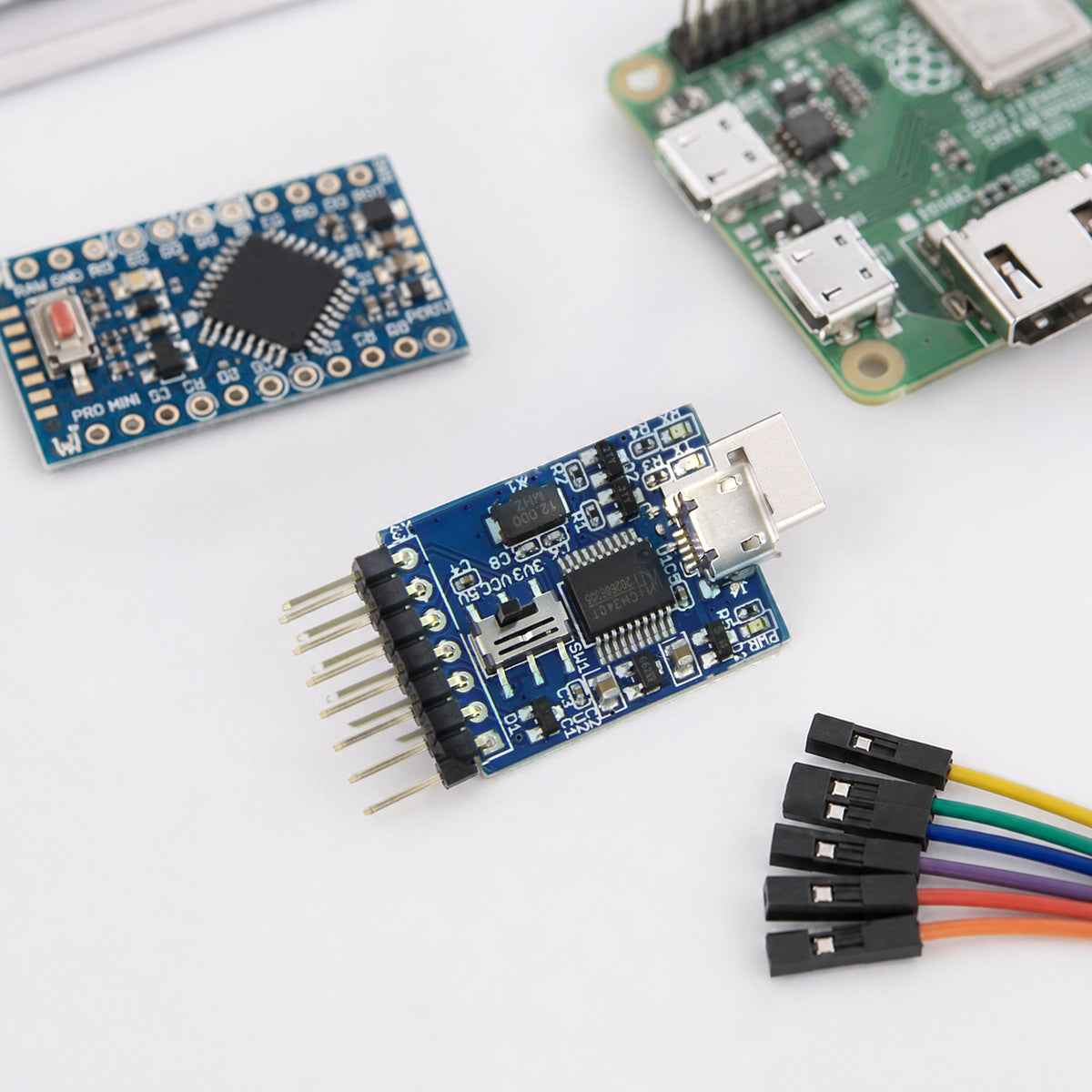 CH340 USB to UART adapter – top-down on an electronics workbench: the adapter next to an Arduino Pro Mini