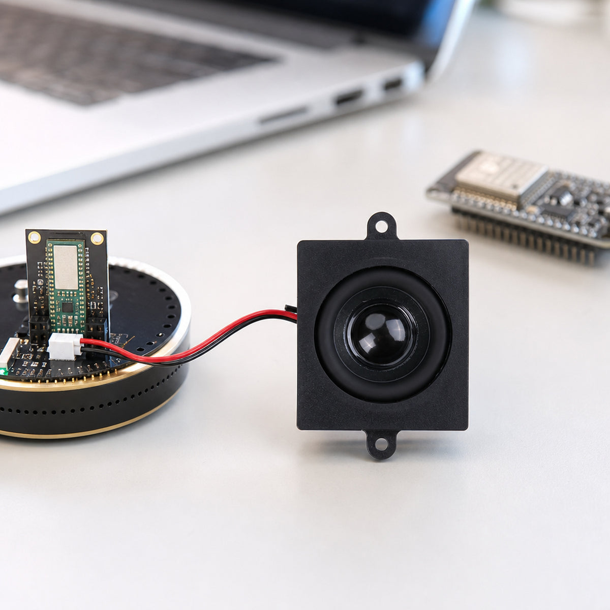 Mono enclosed speaker 4 ohm 5 W – the small speaker wired to a ReSpeaker voice assistant board on a workbench next to an ESP32 dev board and a laptop