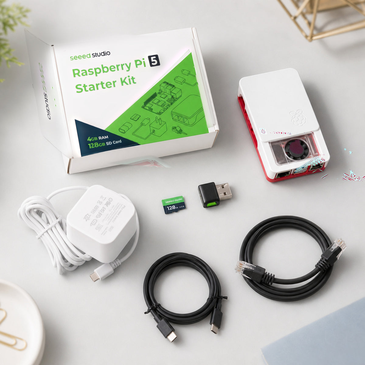 Raspberry Pi 5 starter kit – top-down flat lay of all kit parts on a light grey background: cased Pi 5
