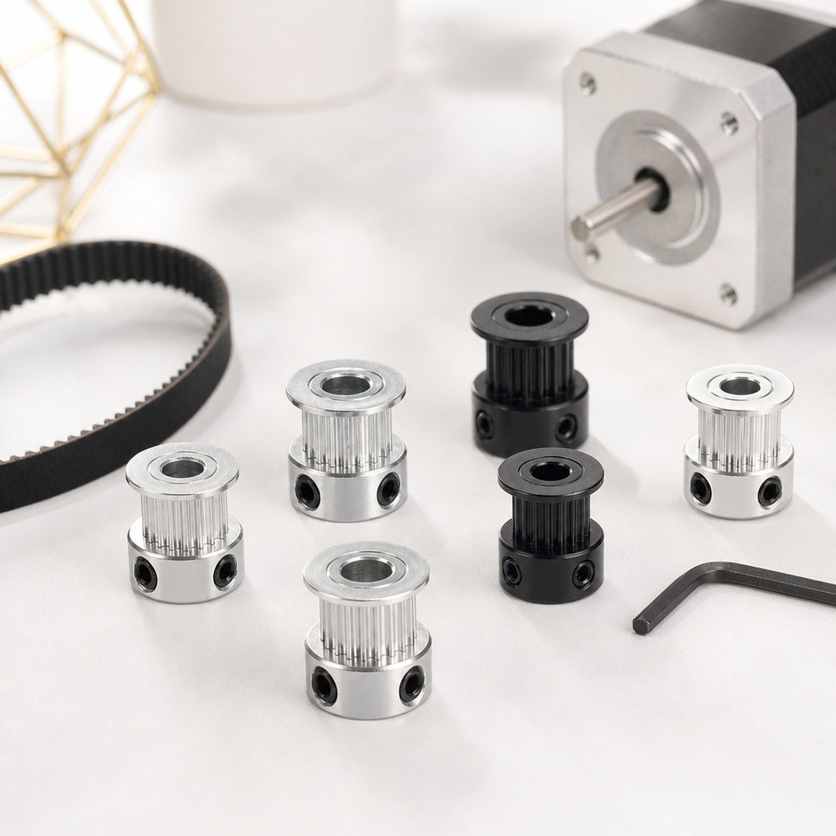 GT2 timing pulleys – top-down on a workbench: several silver and black pulleys of different tooth counts next to a GT2 belt