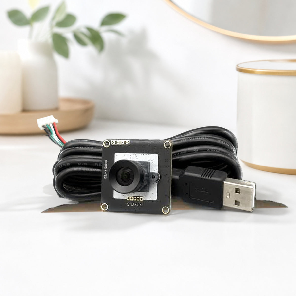 1080p USB camera module – product still life on white: the module with its USB cable coiled