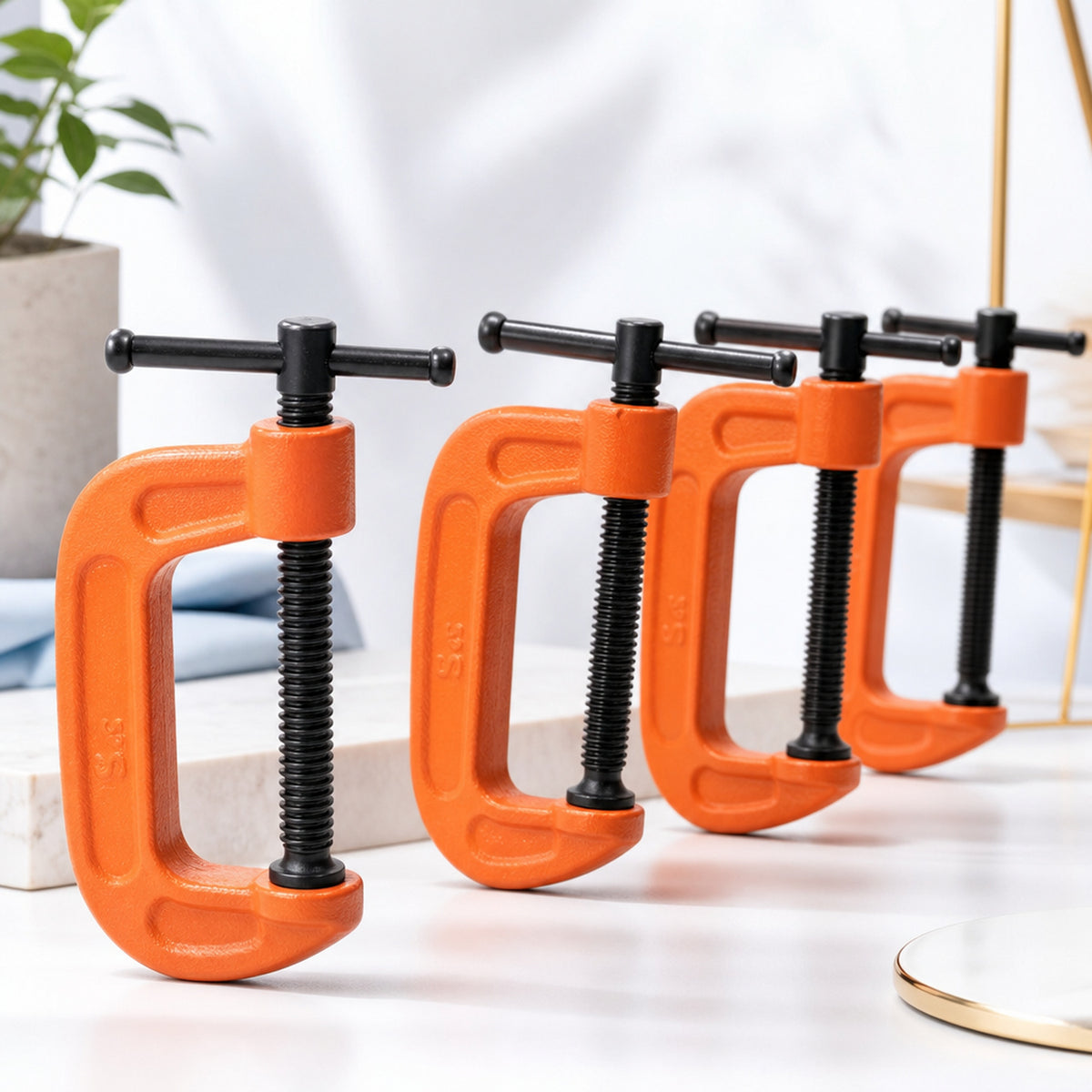 Heavy-duty G-clamps – product still life on white: four clamps in a row