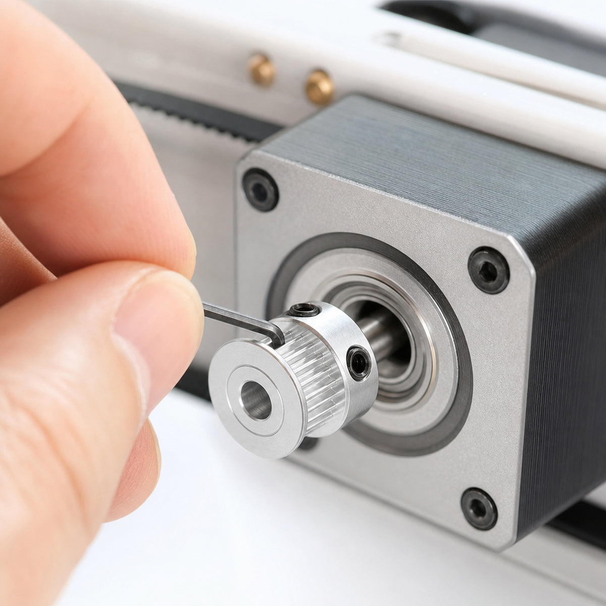 GT2 timing pulleys – an engineer's fingers tightening the grub screw of the pulley with a small hex key on a motor shaft