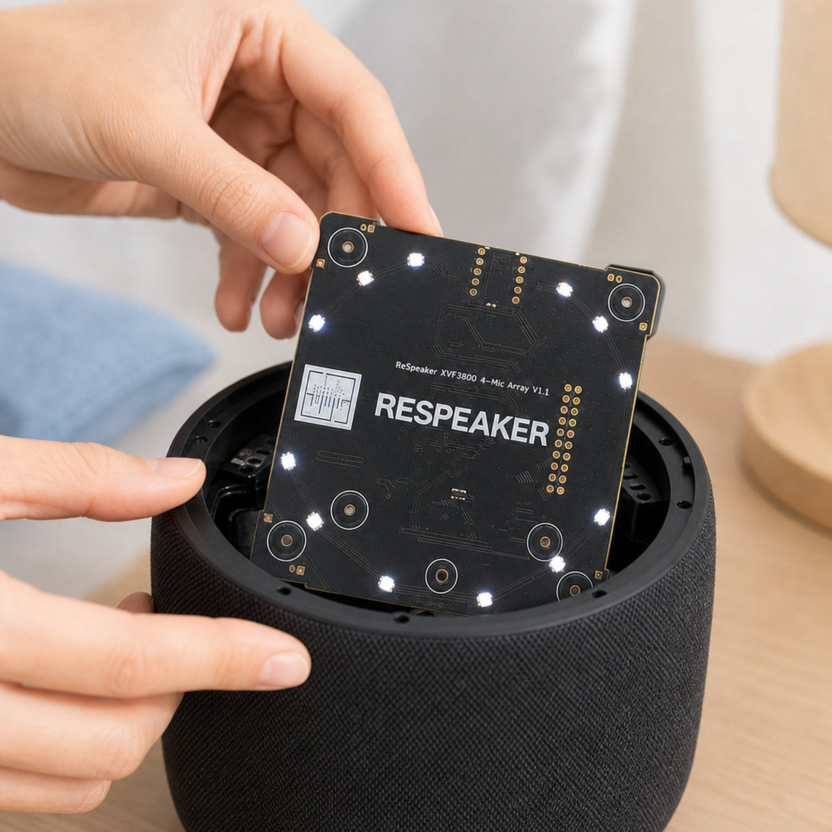 ReSpeaker XVF3800 4-mic array – close-up of hands mounting the mic array board inside a round smart-speaker enclosure