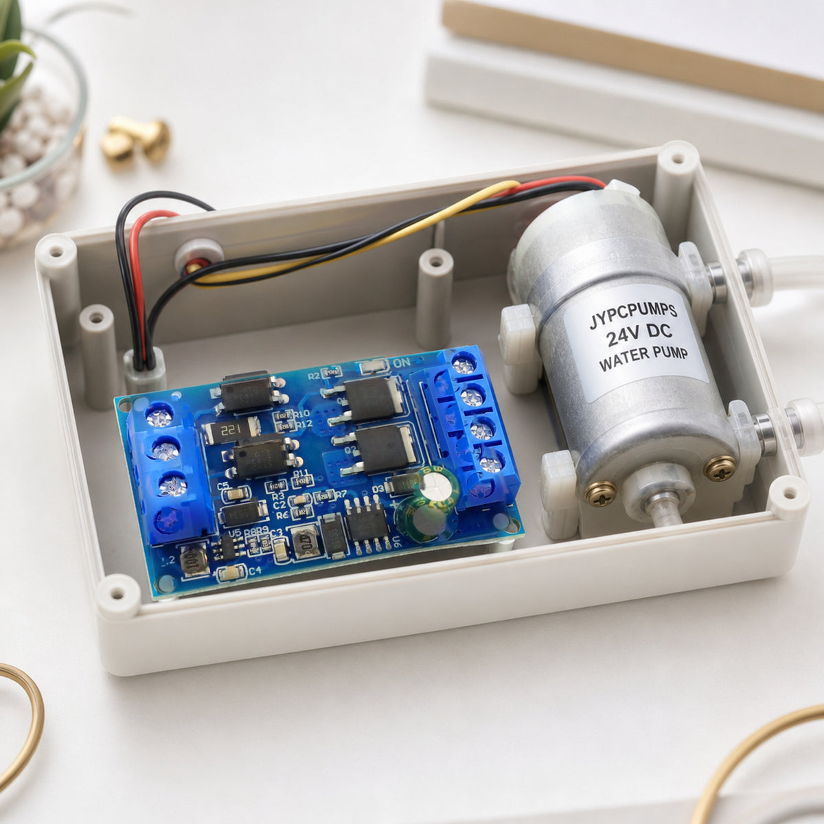 MOSFET PWM switch module – the module mounted inside an open DIY project enclosure next to a 24V water pump