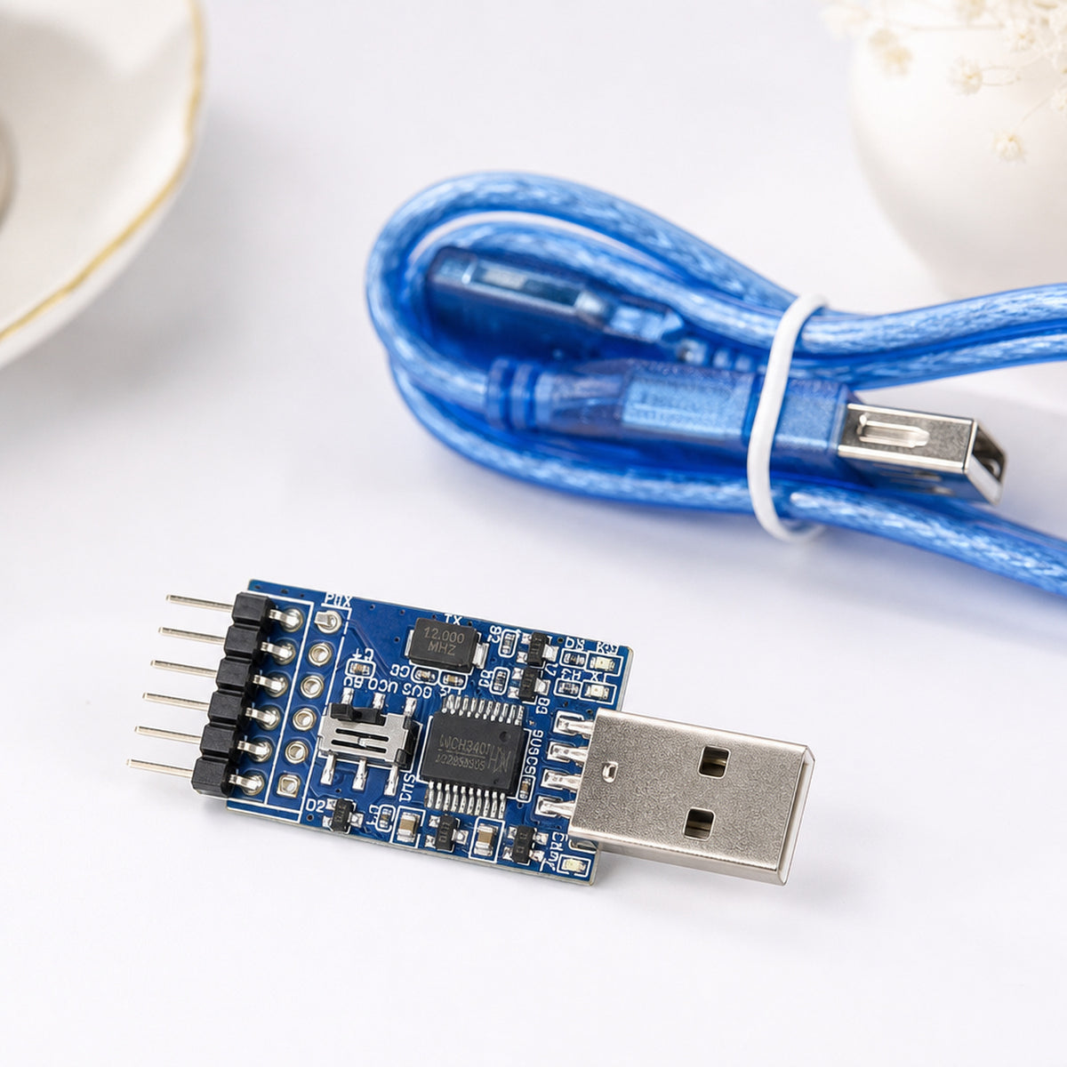 CH340 USB to UART adapter – the adapter on a clean white background next to a coiled USB extension cable